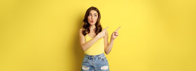 Photo portrait of young woman standing against yellow background