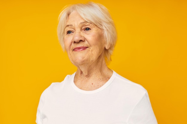 Portrait of young woman standing against yellow background