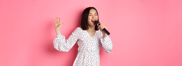 Photo portrait of young woman standing against yellow background