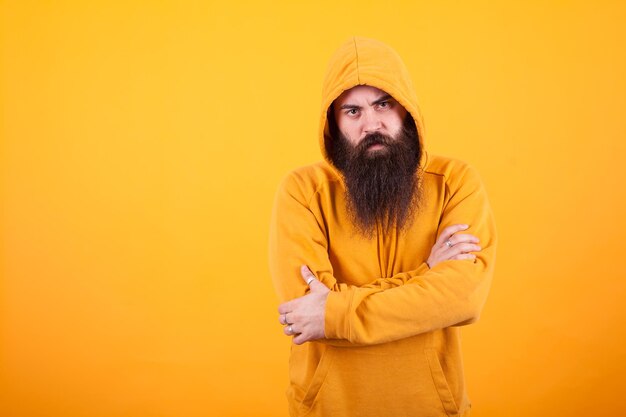 Portrait of young woman standing against yellow background