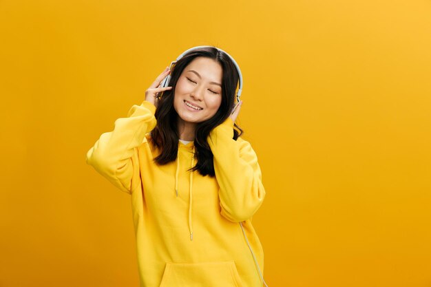 Portrait of young woman standing against yellow background