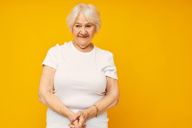 Portrait of young woman standing against yellow background