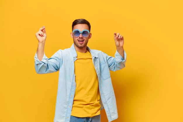 Portrait of young woman standing against yellow background