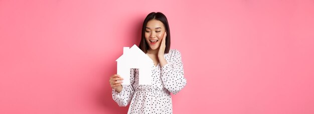 Photo portrait of young woman standing against yellow background