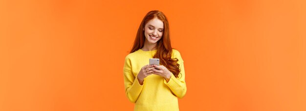 Portrait of young woman standing against yellow background