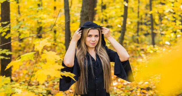 Portrait of young woman standing against yellow plants