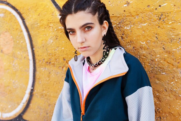 Photo portrait of young woman standing against yellow wall