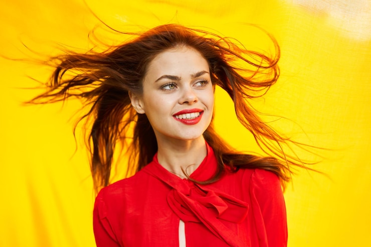 Фотография портрет молодой женщины, стоящей у желтой стены