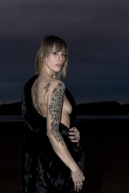 Photo portrait of young woman standing at beach against sky