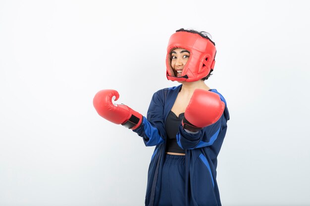 Portrait of a young woman standing in boxing gloves .