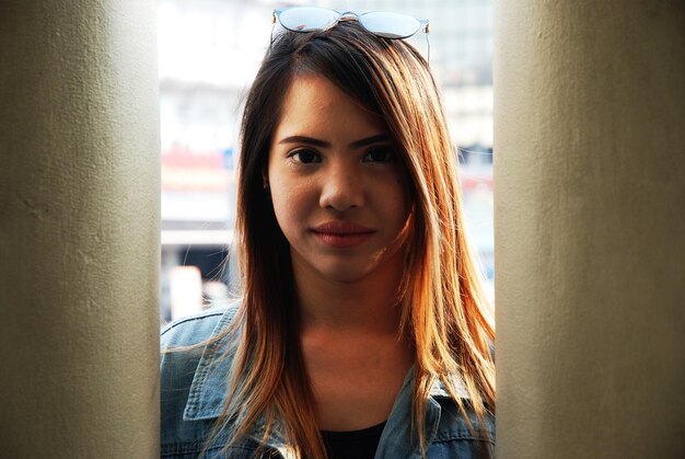 Photo portrait of young woman standing by columns