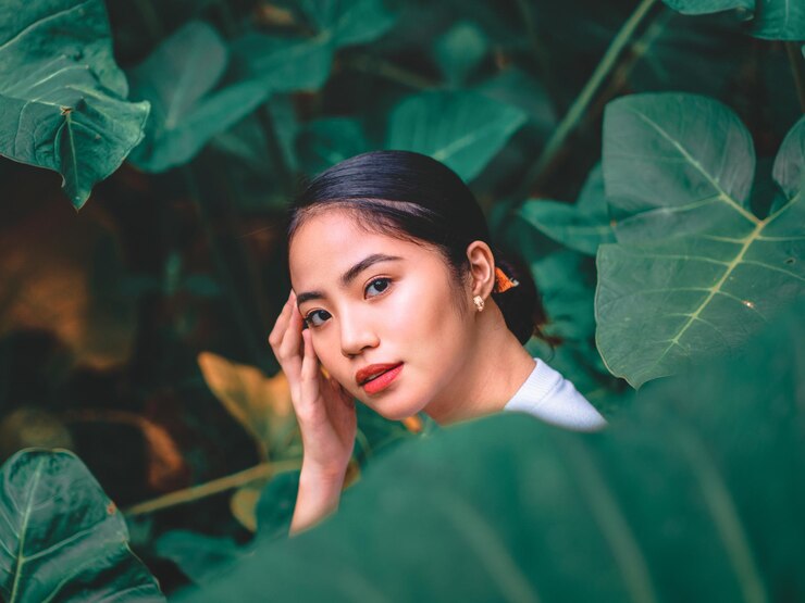 Photo 外で植物のそばに立っている若い女性の肖像画