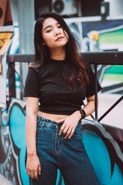 Portrait of young woman standing by railing