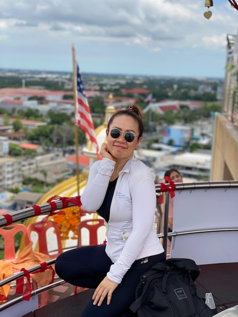 Portrait of young woman standing by railing