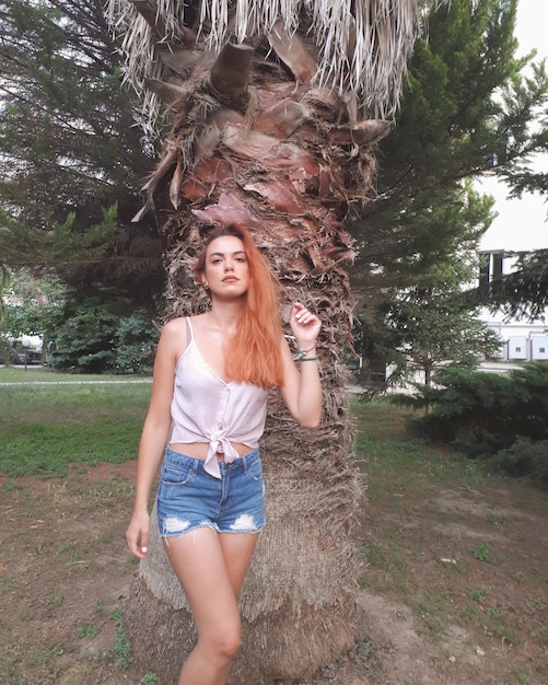 Photo portrait of young woman standing by tree on field