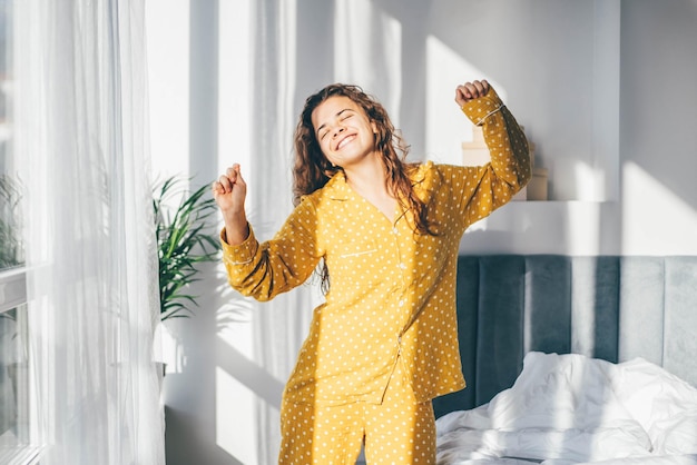 Photo portrait of young woman standing by window