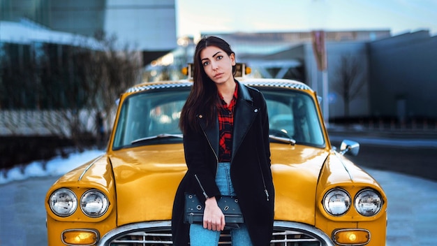 portrait of young woman standing by yellow car