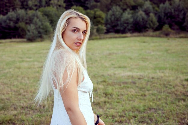 Portrait of young woman standing on field