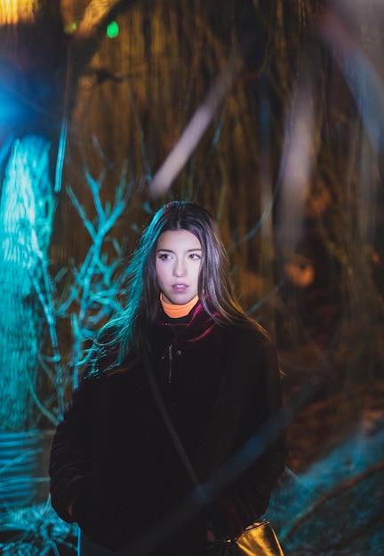 Portrait of young woman standing in forest