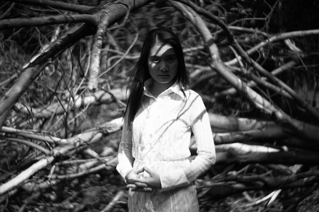 portrait of young woman standing in forest
