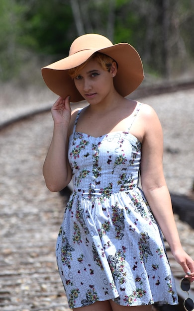 Photo portrait of young woman standing on railroad track during sunny day