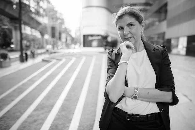 Foto ritratto di una giovane donna in piedi per strada in città