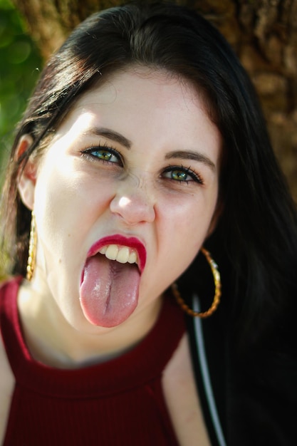 Foto ritratto di una giovane donna che tira fuori la lingua