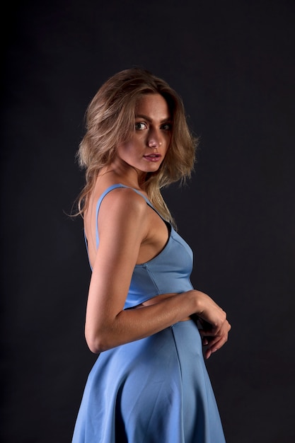 portrait of a young woman in the studio on a dark background