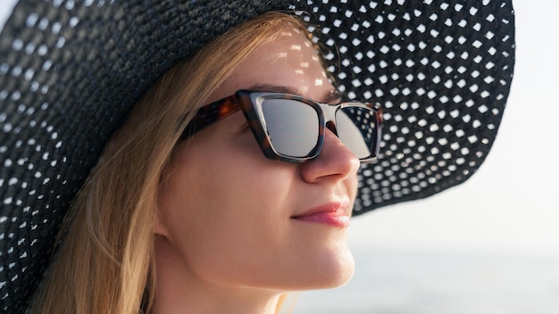 Foto ritratto di una giovane donna in abito estivo e cappello durante le vacanze estive