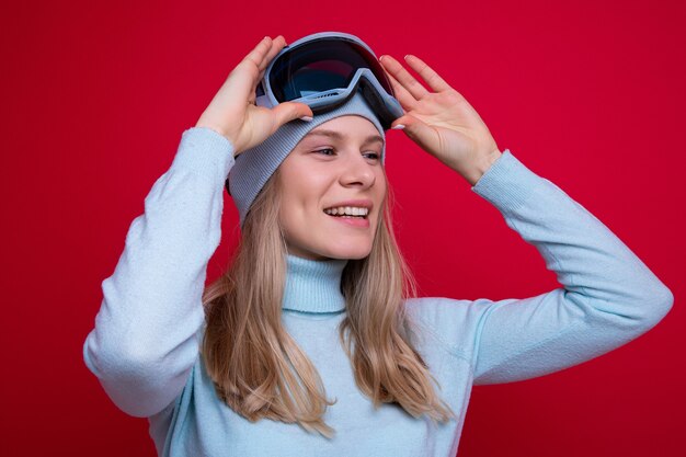 Portrait of a young woman in a sweater and ski goggles