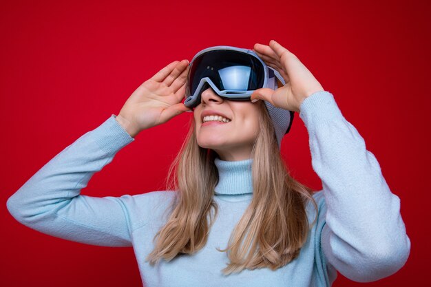 Portrait of a young woman in a sweater and ski goggles