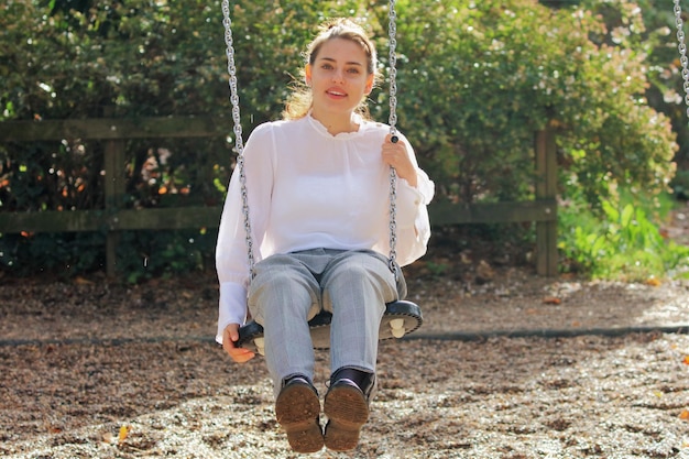 Photo portrait of young woman swinging during sunny day