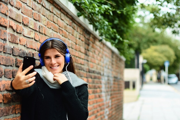 Portrait of young woman taking selfie.