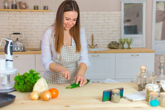 Portrait of a young woman talking on the phone in the kitchen