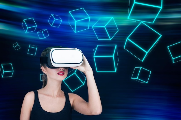 Portrait of a young woman in a tank top wearing virtual reality glasses. There are white cubes with shining lines in the background. Mock up