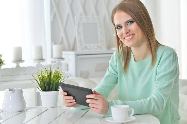 Portrait of young woman using digital tablet at home