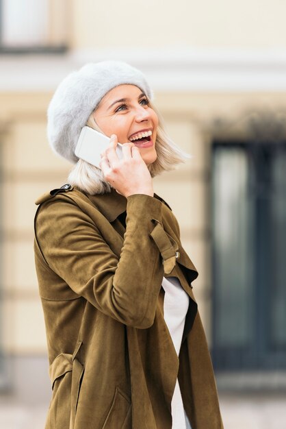 彼女の携帯電話を使用して若い女性の肖像画。自然人。