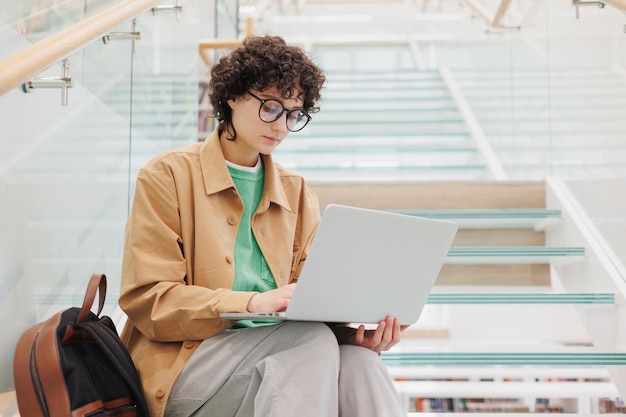 Photo portrait of young woman using laptop while sitting in office