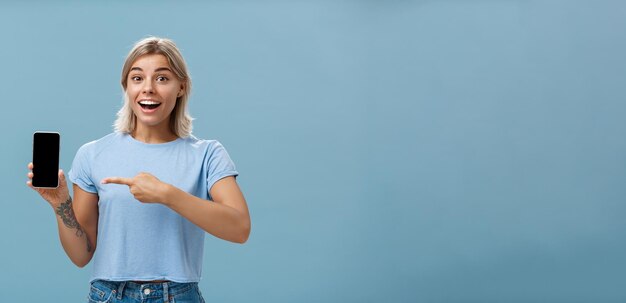 Portrait of young woman using mobile phone against blue background