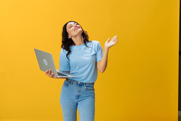 Portrait of young woman using mobile phone against yellow background