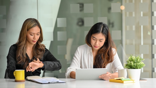 Portrait of young woman using mobile phone in office