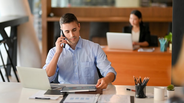 Portrait of young woman using mobile phone in office