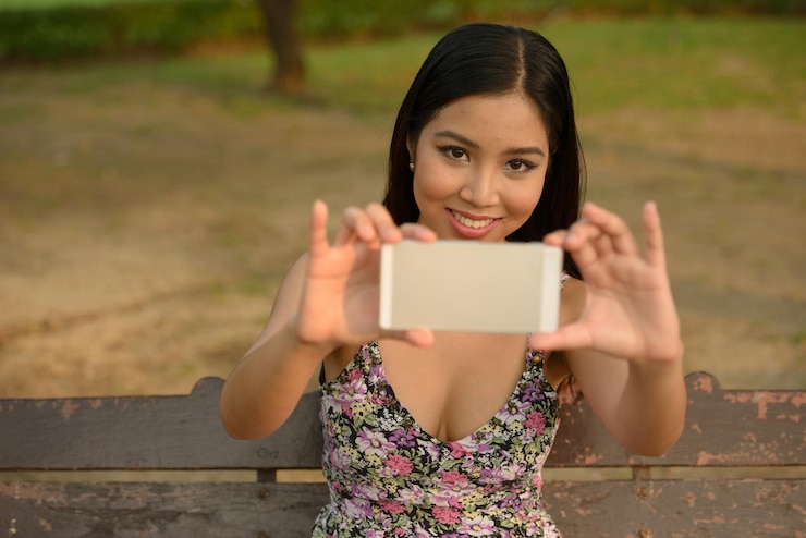 Photo portrait of young woman using mobile phone outdoors