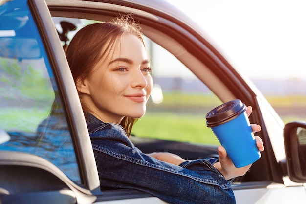 Portrait of young woman using mobile phone while sitting in car