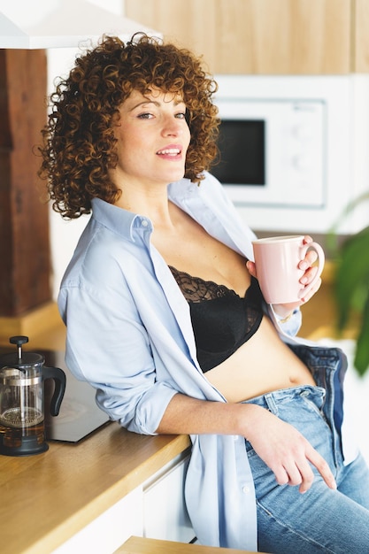 Photo portrait of young woman using mobile phone while sitting at home