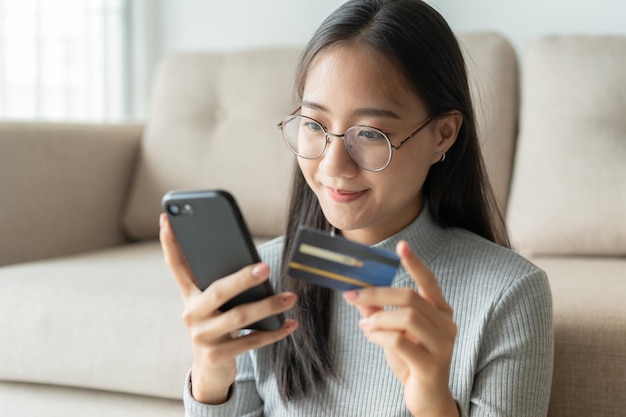 portrait of young woman using mobile phone while sitting on sofa
