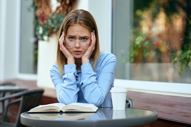 portrait of young woman using mobile phone while sitting on table