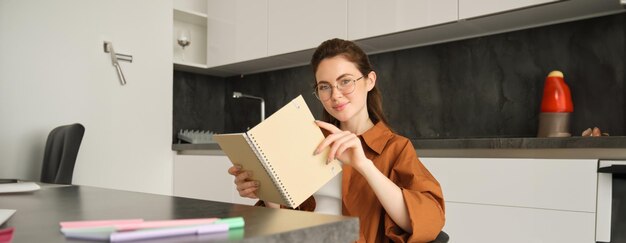 Photo portrait of young woman using mobile phone while sitting on table