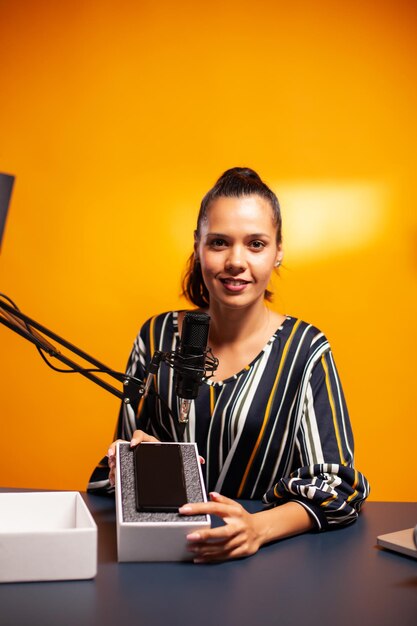 Photo portrait of young woman using mobile phone while sitting on table