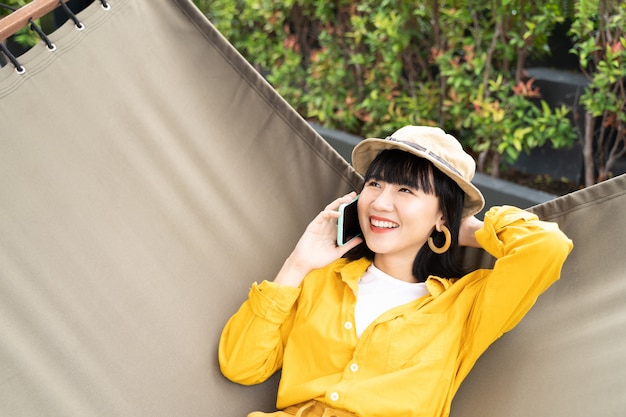 Portrait of young woman using mobile with happy and relaxed at home